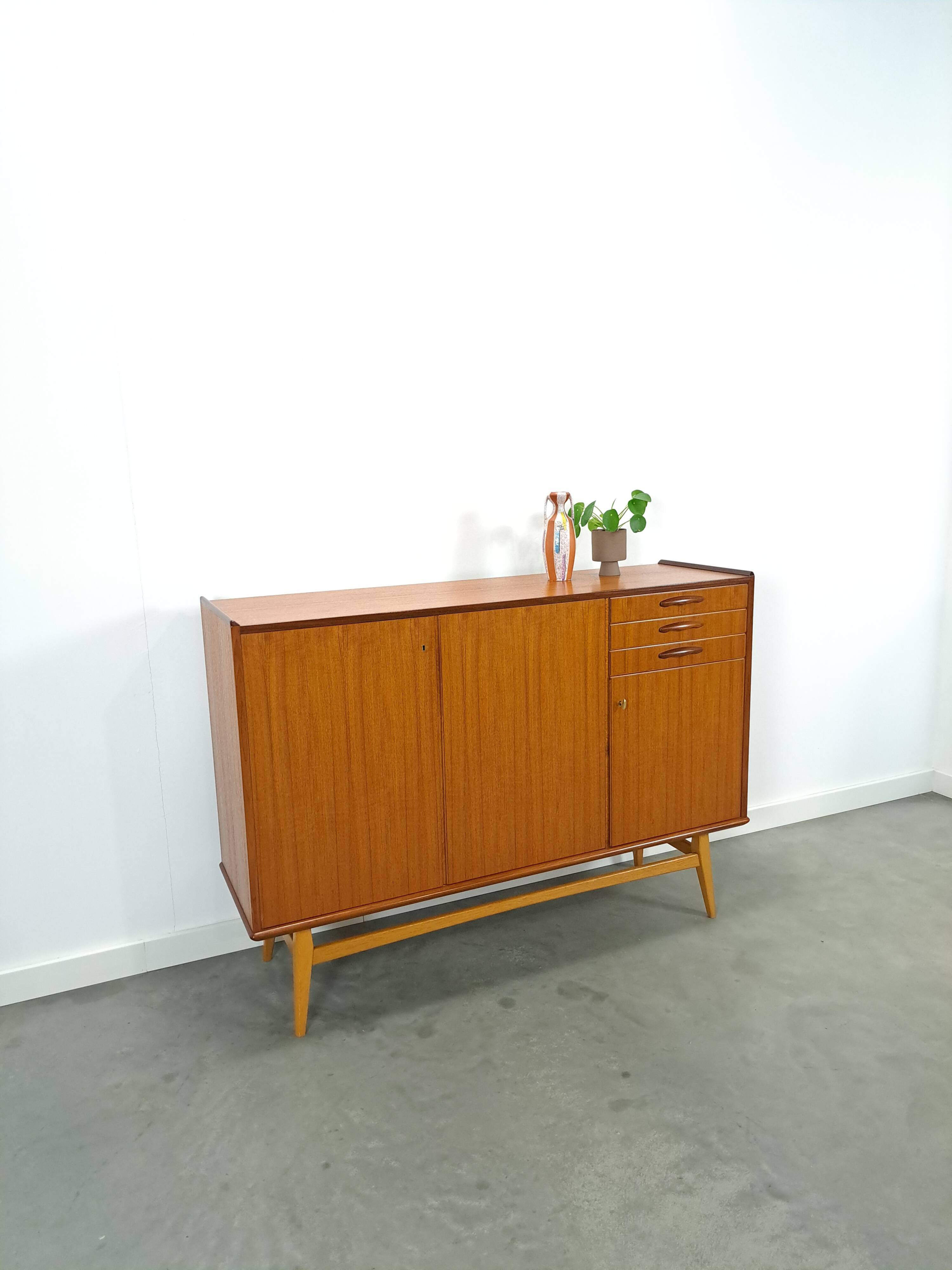 Teak kast met schuine poten en lades uit Zweden