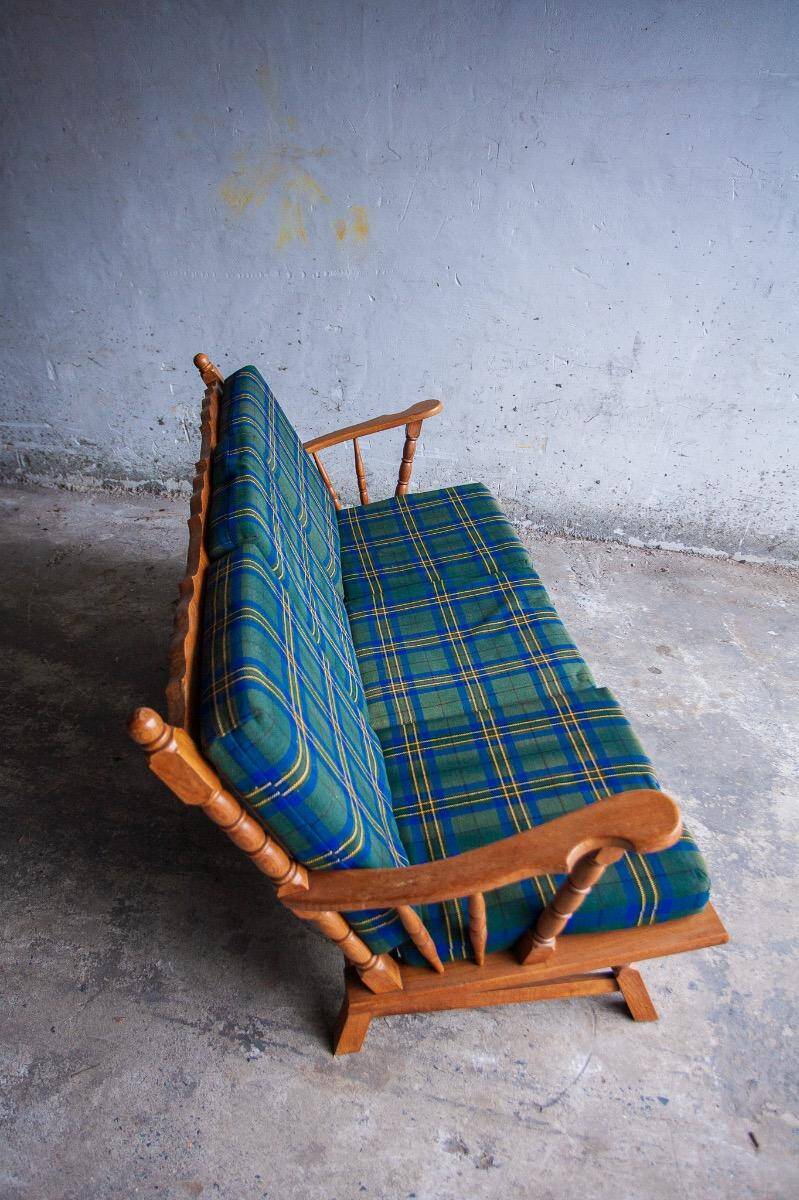 Canapé 3 places en chêne style années 50, avec tissu à carreaux vert-bleu et accoudoirs à fuseaux tournés.