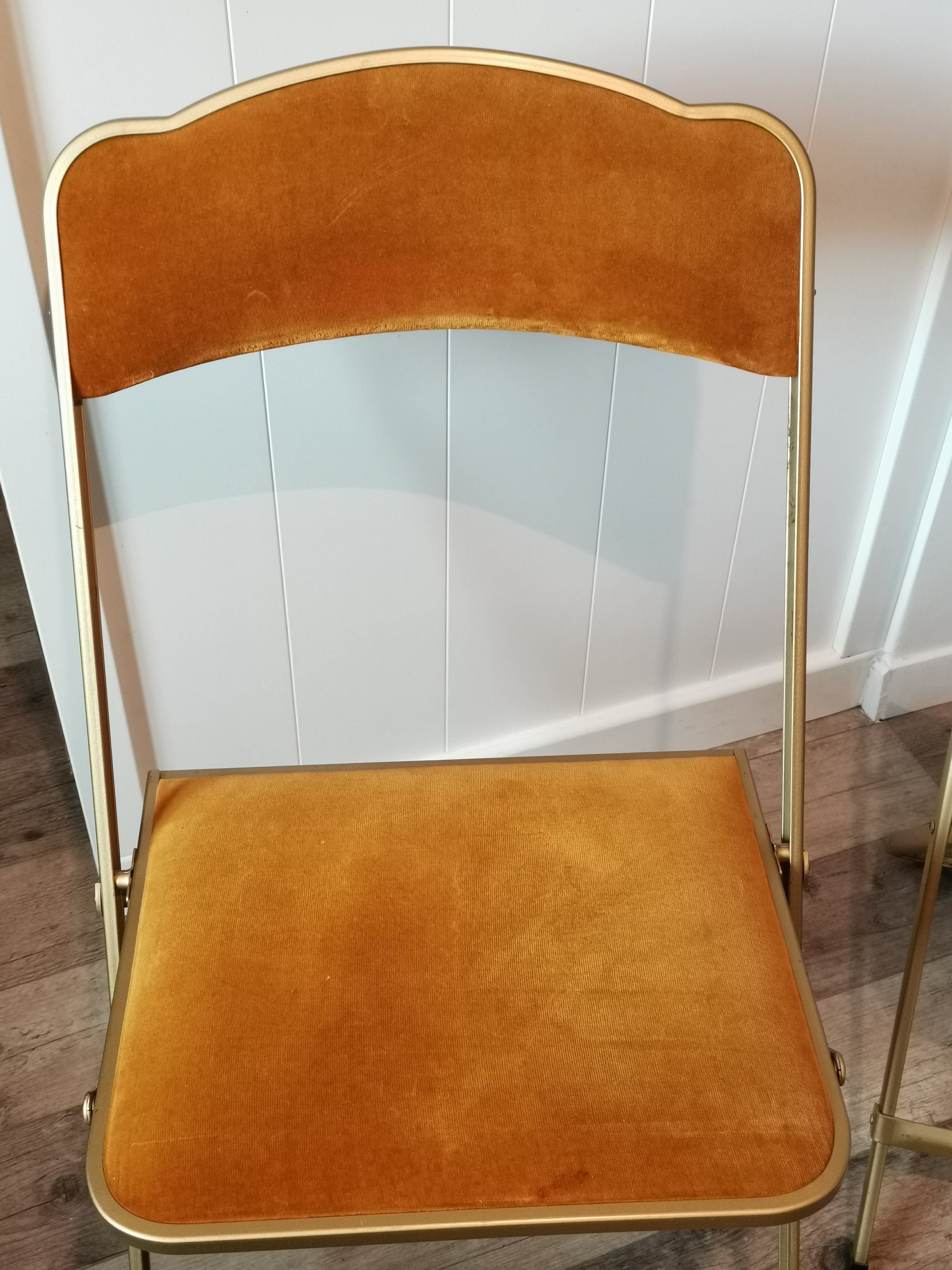 Two gold velvet folding chairs