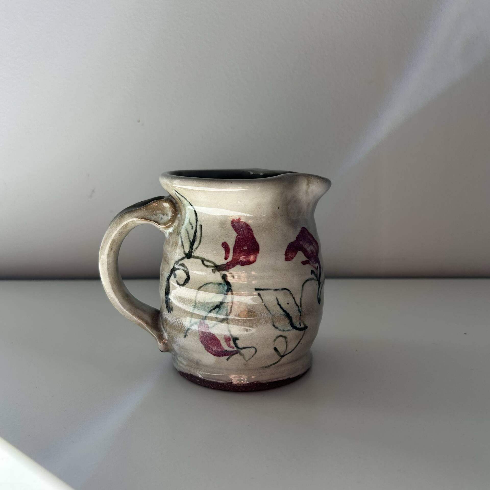 Floral decorated pitcher signed