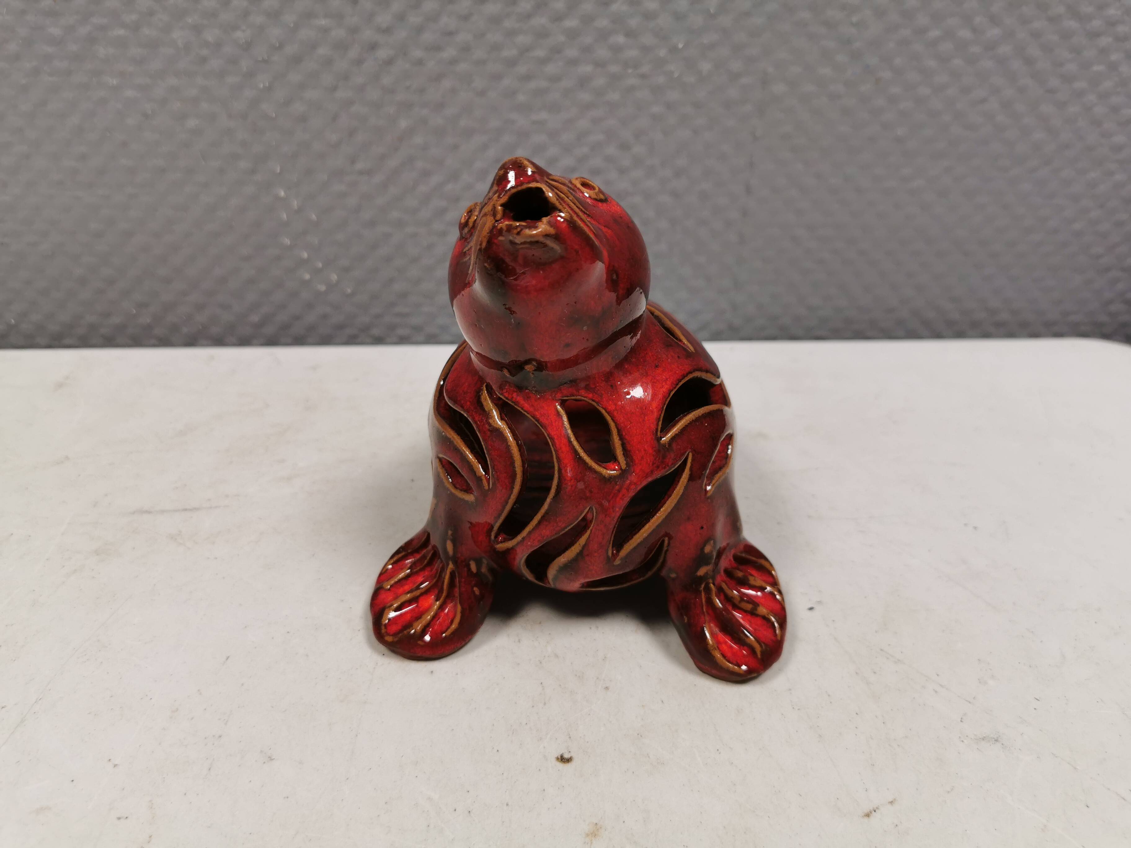 Beautiful seal in ceramic with metallic red glaze.