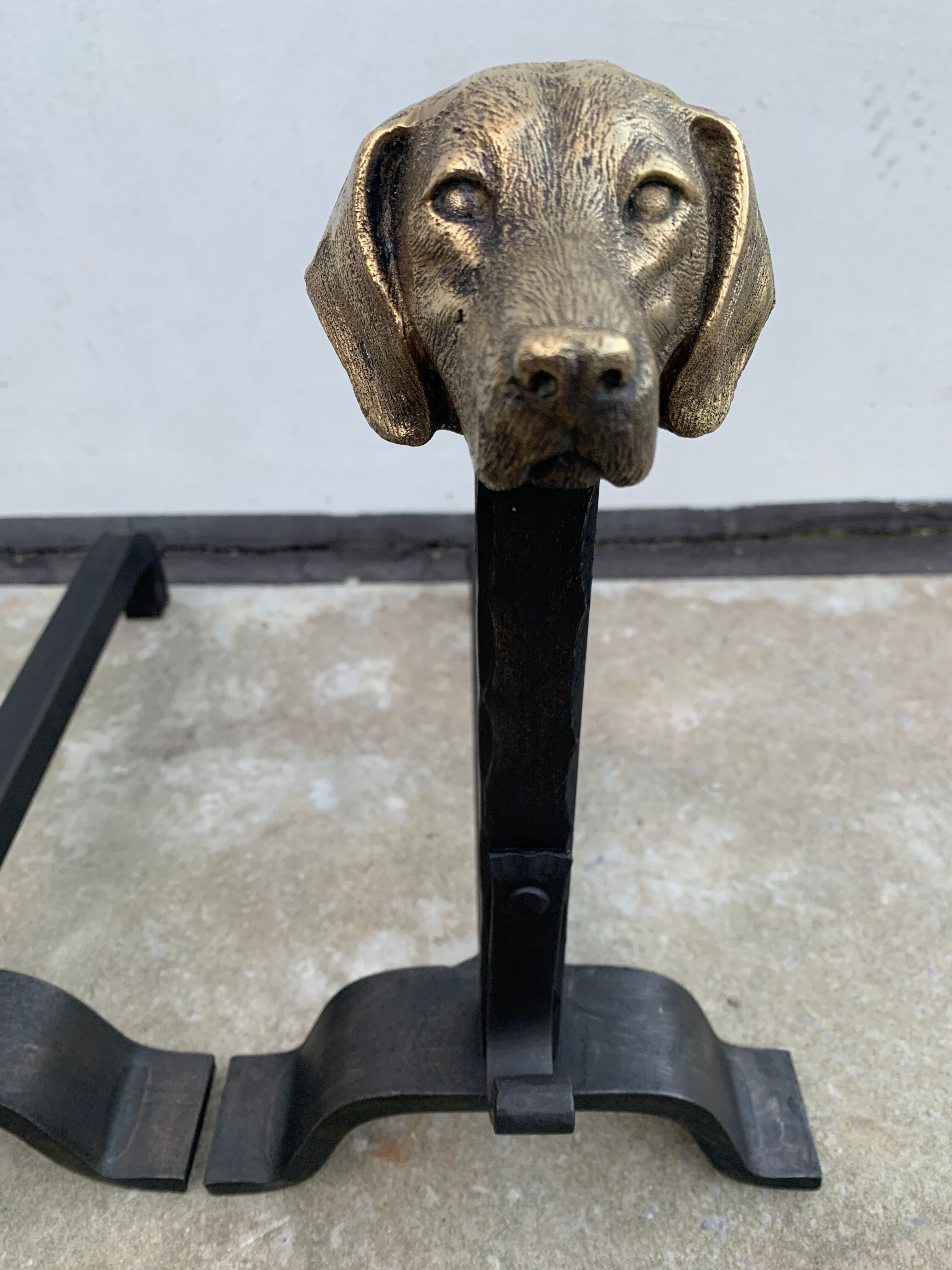 Pair of metal chenets decorated with brass dog heads