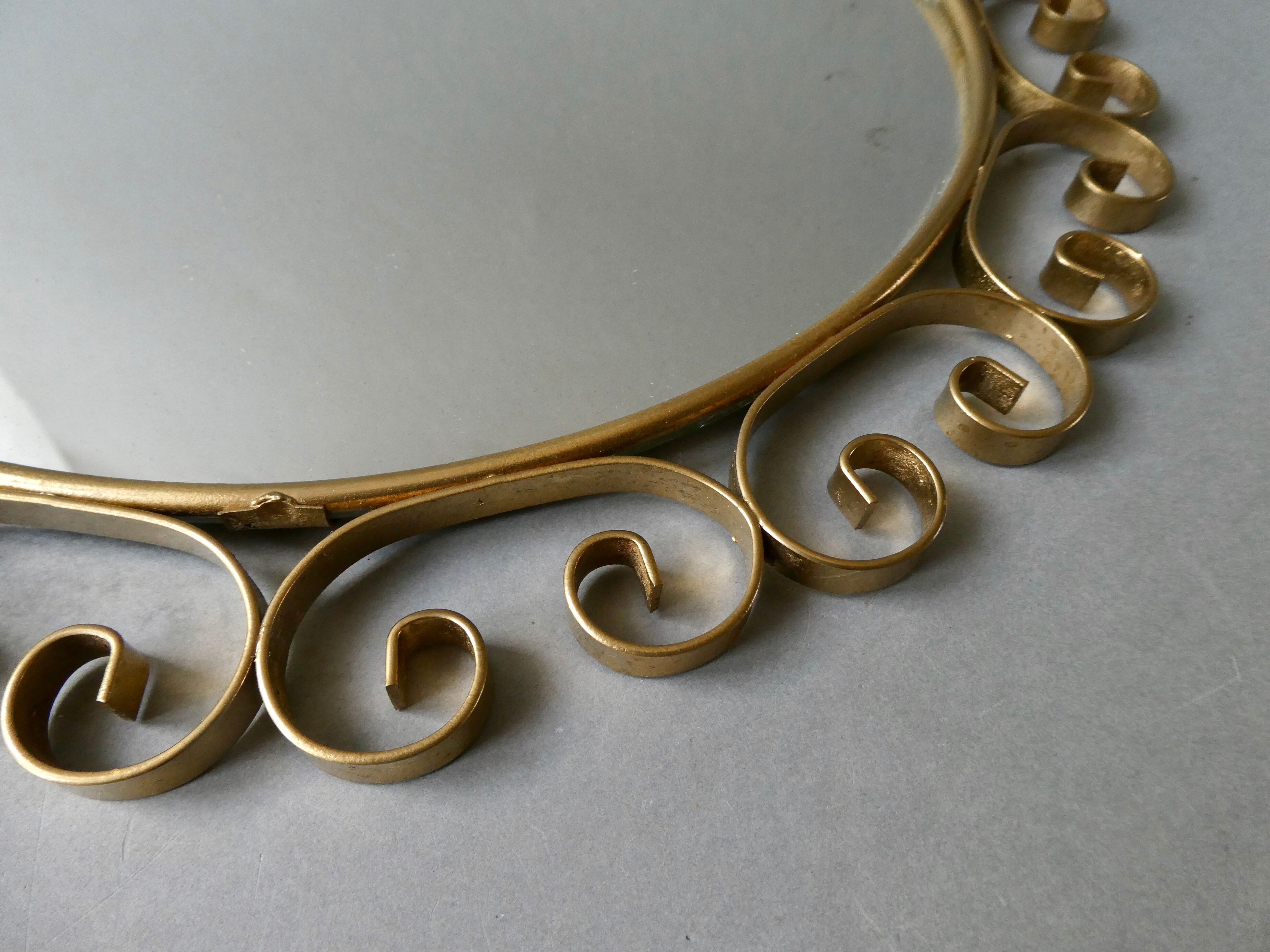Round mirror with golden metal arabesques