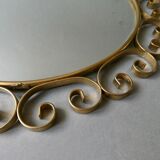 Round mirror with golden metal arabesques