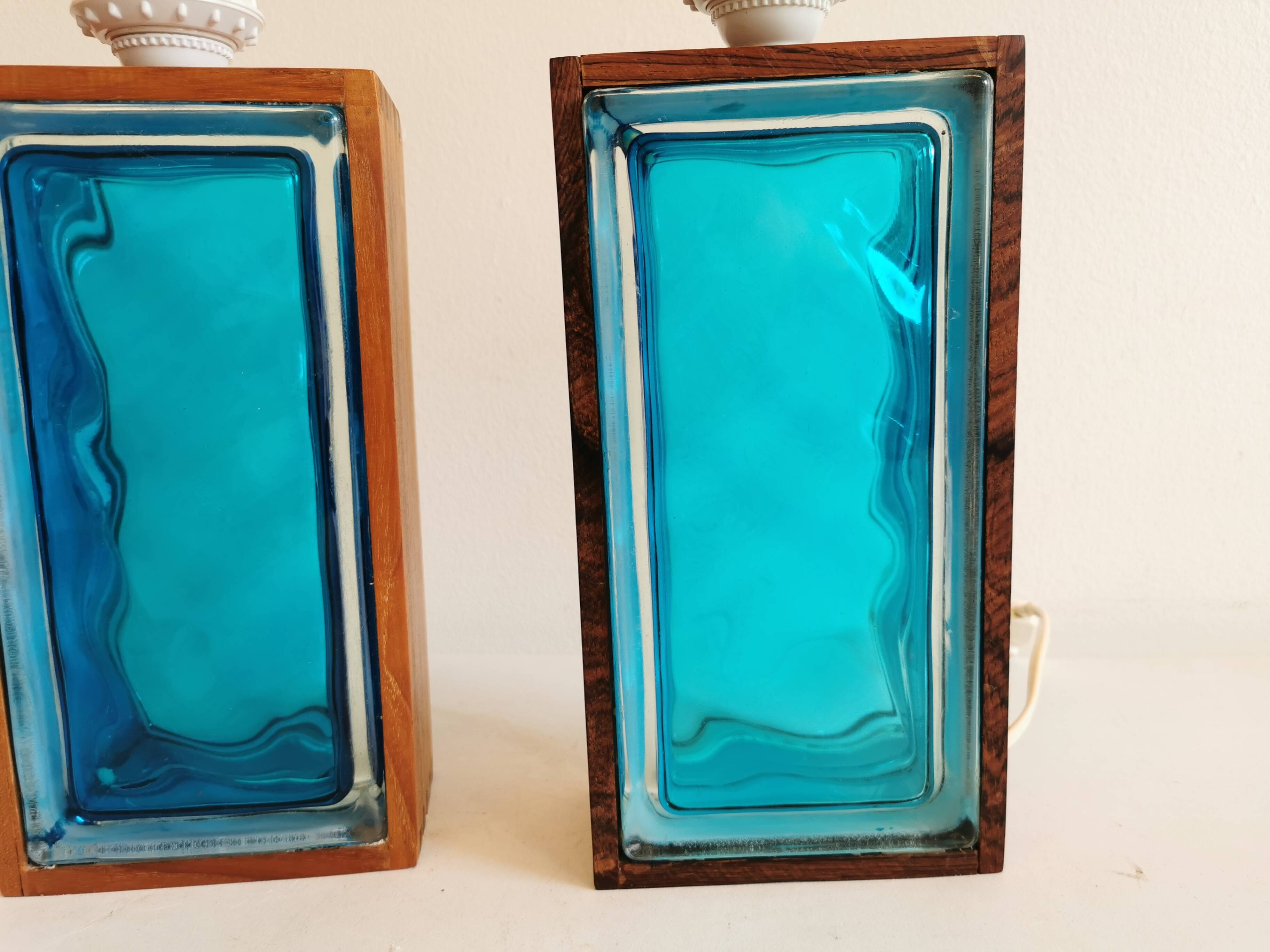 Two Swedish table lamps in solid pressed blue glass and teak wood "frame".
