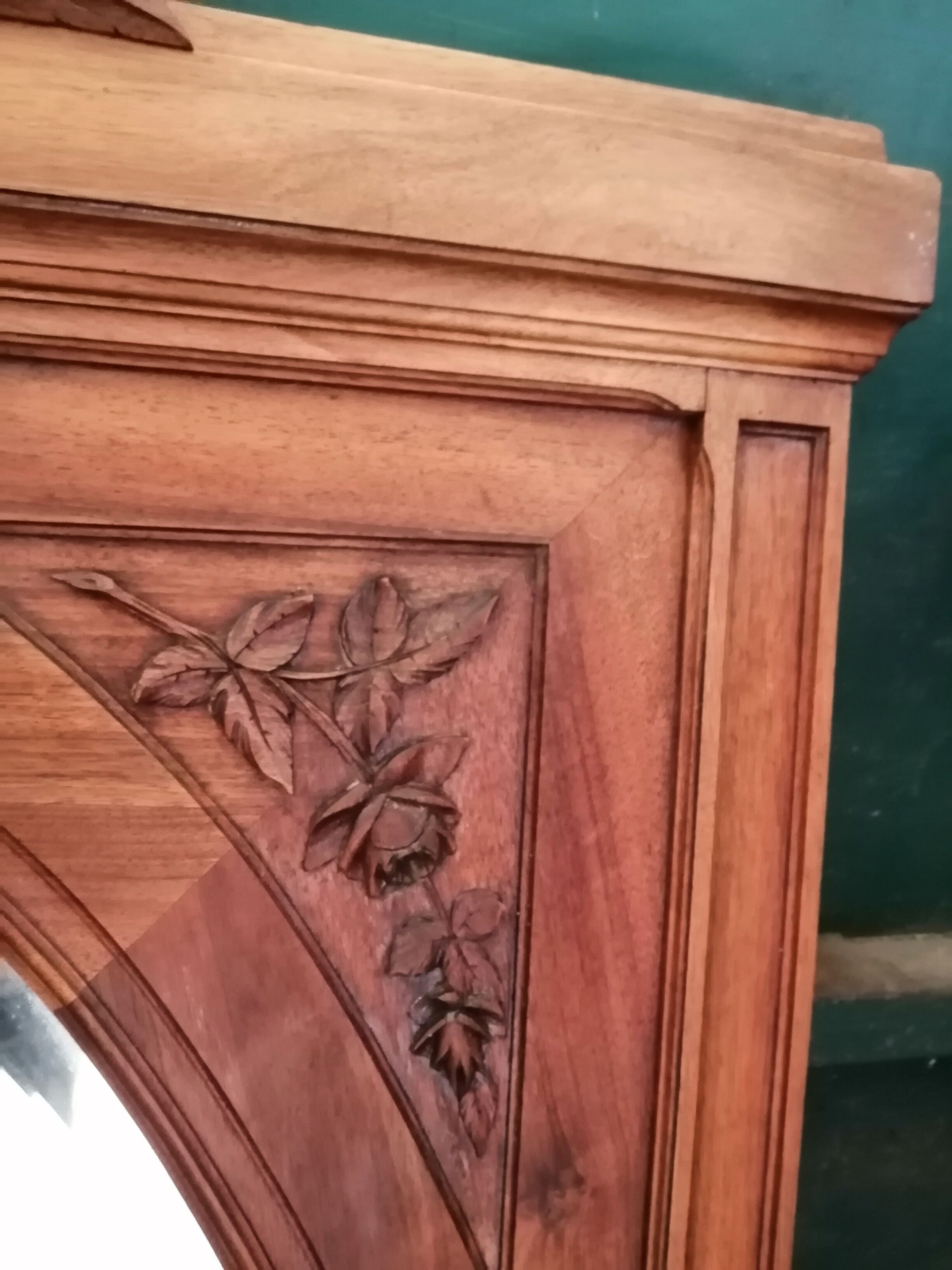 Old oval walnut wood mirror has flower carvings decoration