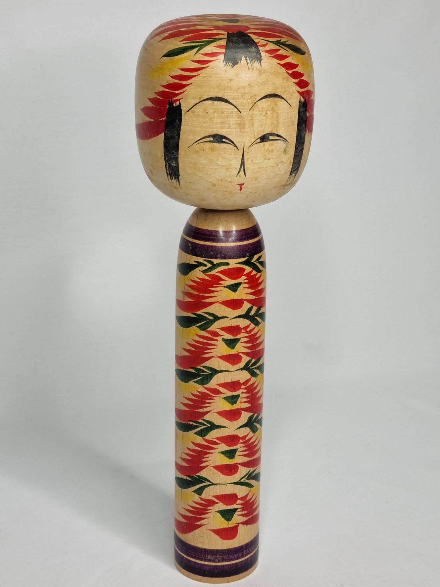 Japanese Kokeshi doll dated 1986, signed and numbered, hand-painted multi-colored floral decoration,