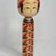 Japanese Kokeshi doll dated 1986, signed and numbered, hand-painted multi-colored floral decoration,
