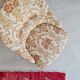 Beige toad armchair with floral patterns and red fringes