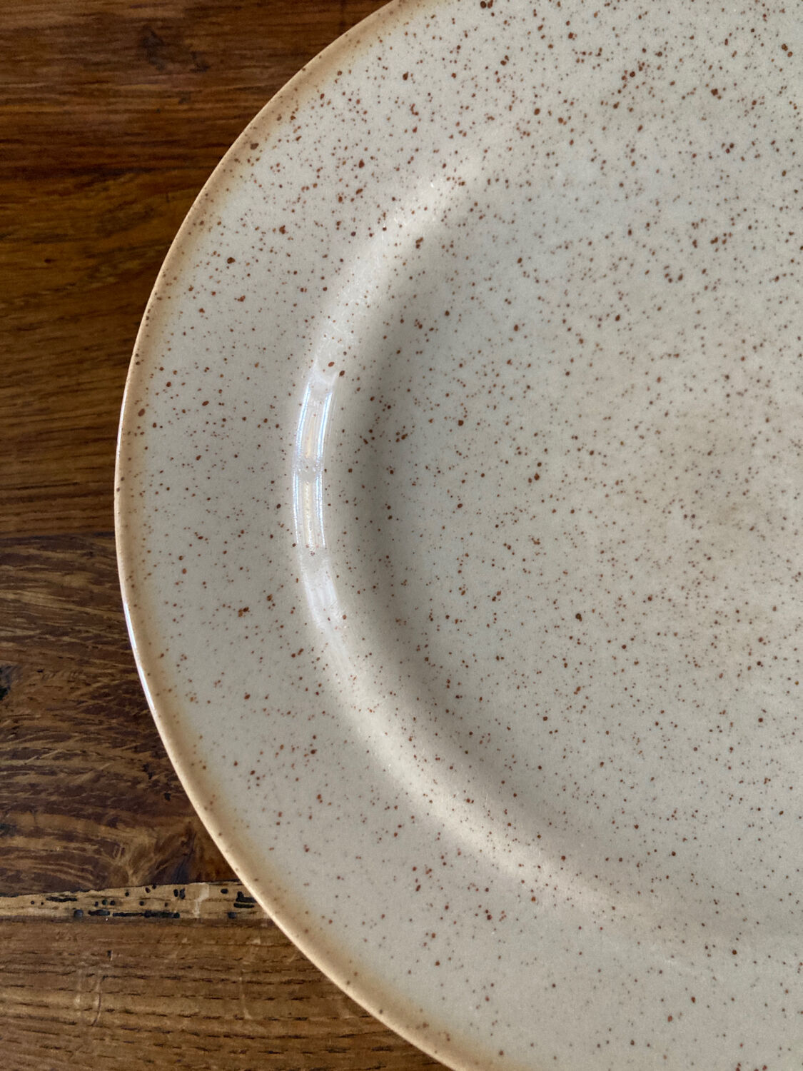 Four beige speckled plates