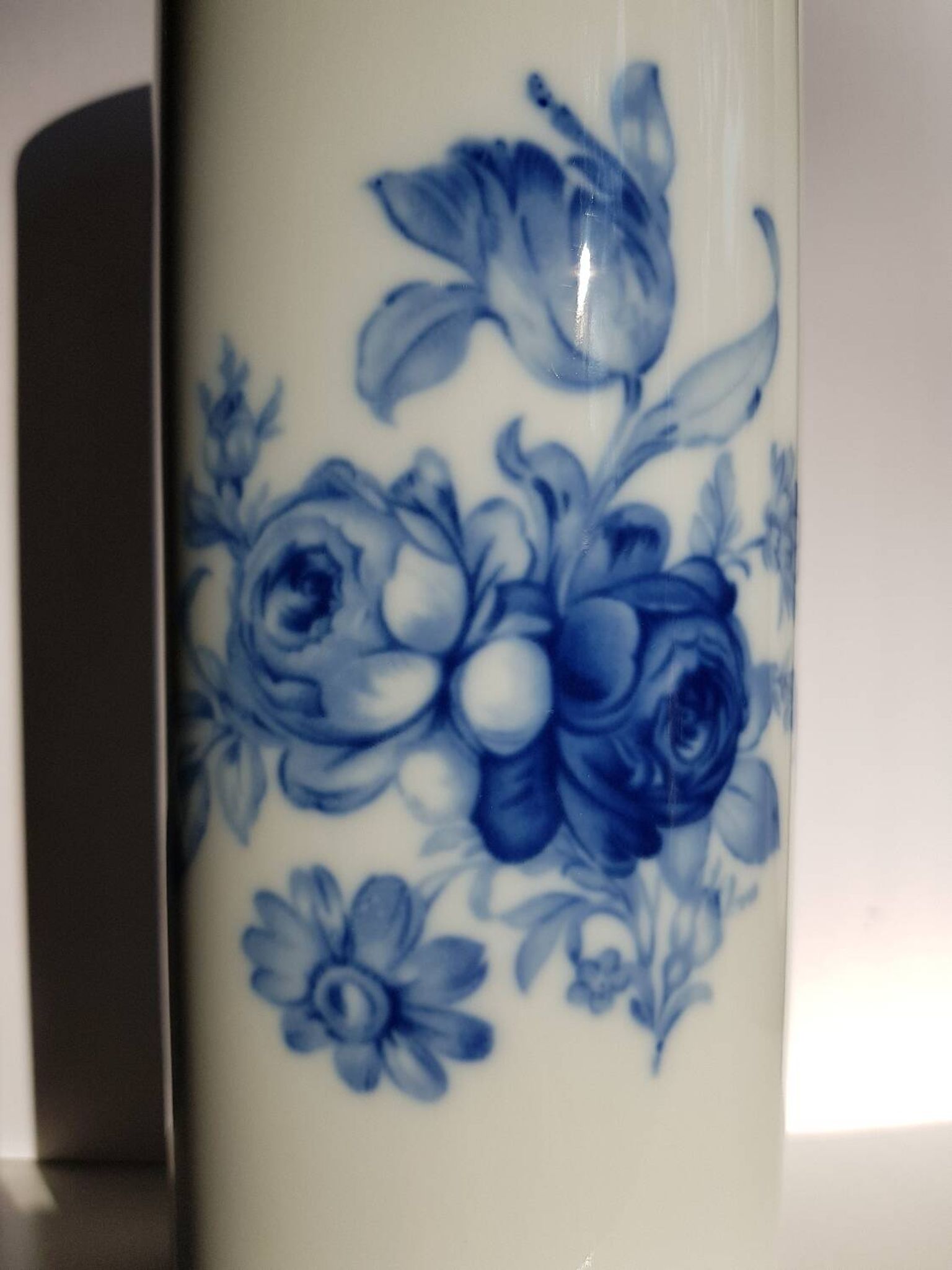 White porcelain vase from Limoges with blue decoration and gold rim.