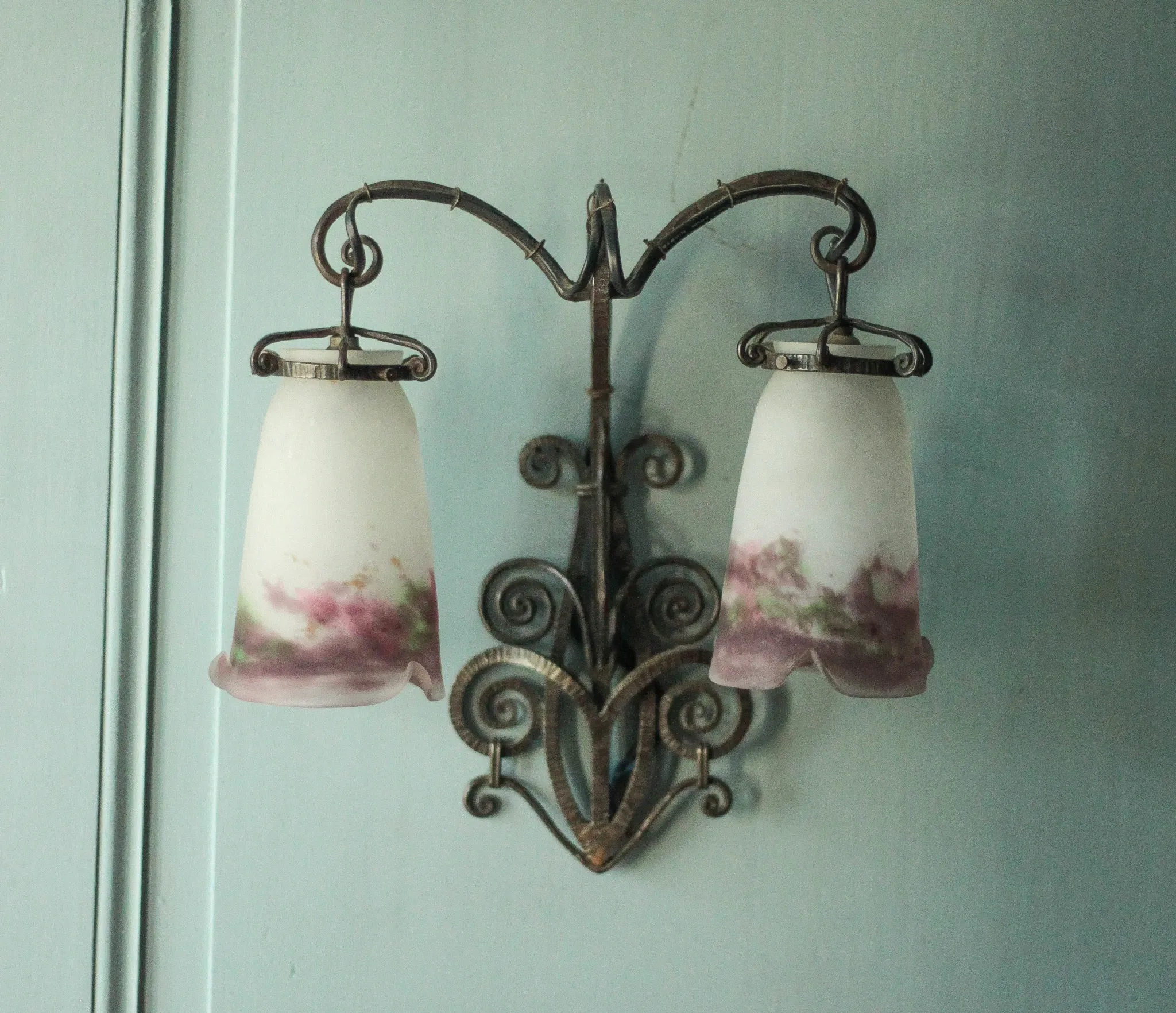 Wall lamp in wrought iron with a pink tulip glass globe by Muller glassworks.