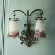 Wall lamp in wrought iron with a pink tulip glass globe by Muller glassworks.