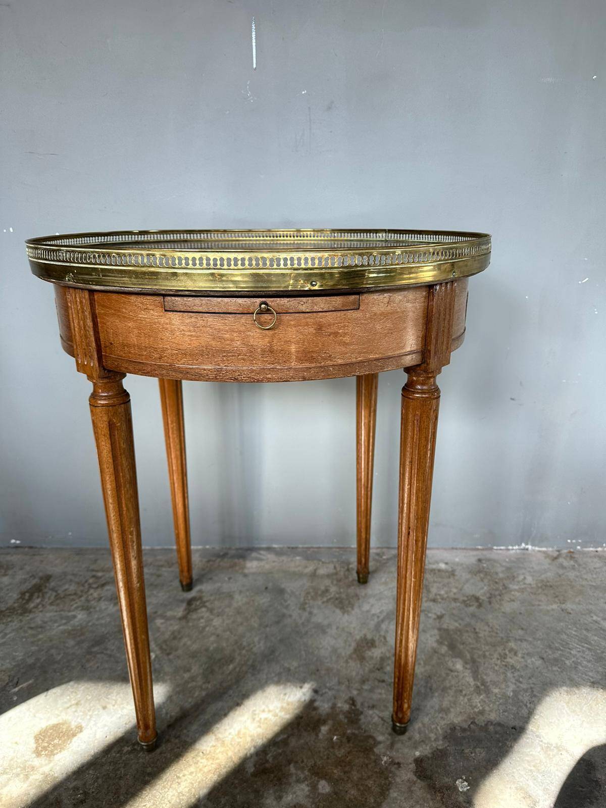 Hot water bottle table with a marble top and a brass gallery.