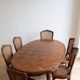 Oval dining table and 6 caned chairs in Louis XVI style made of wood.