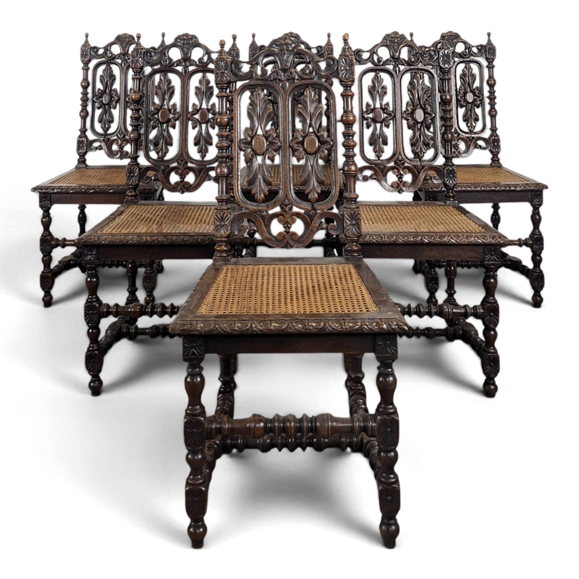 Set of 6 Henri II chairs in carved openwork oak with caned seats.