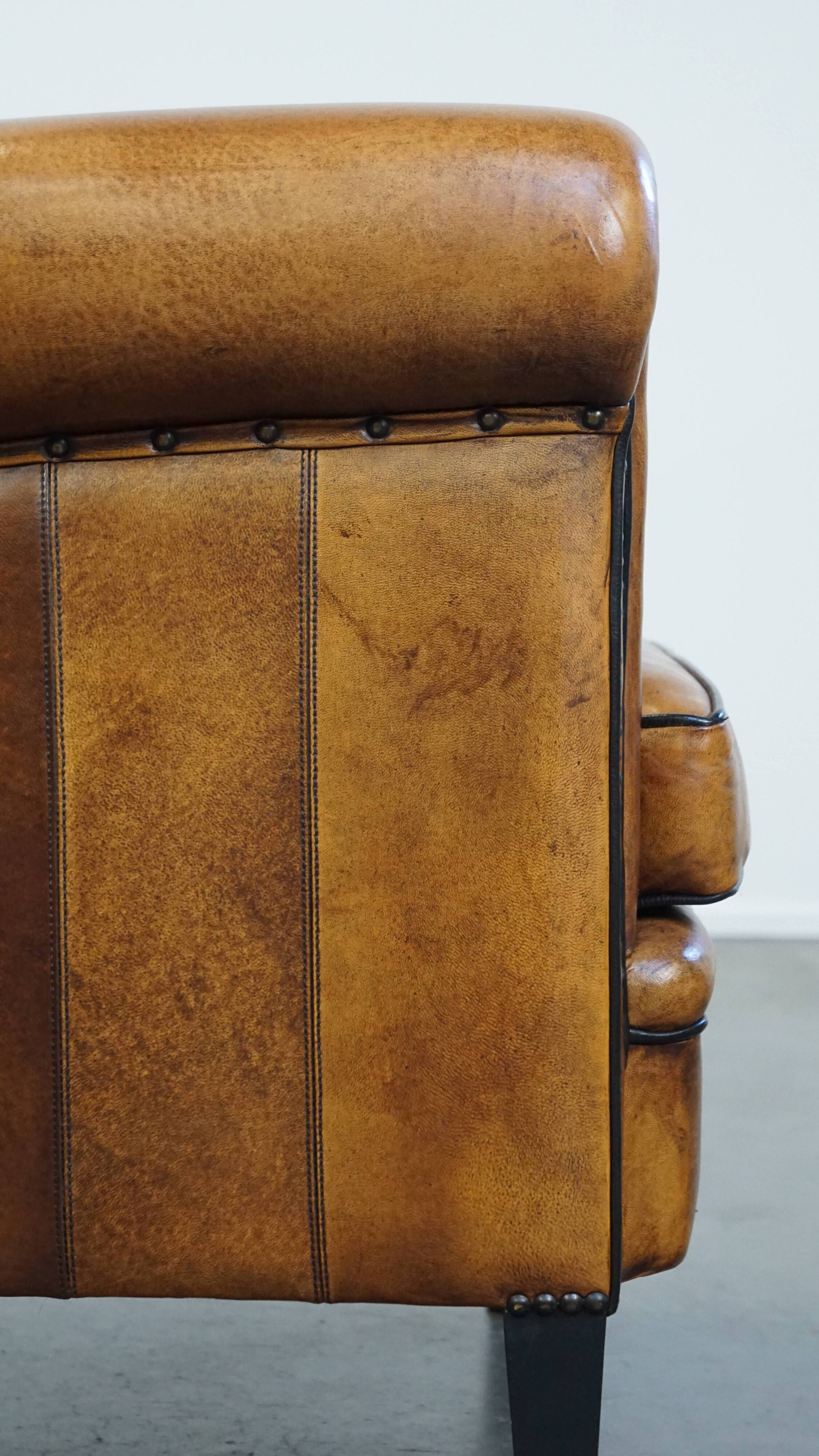 Sheep leather design armchair finished with decorative nails and black piping