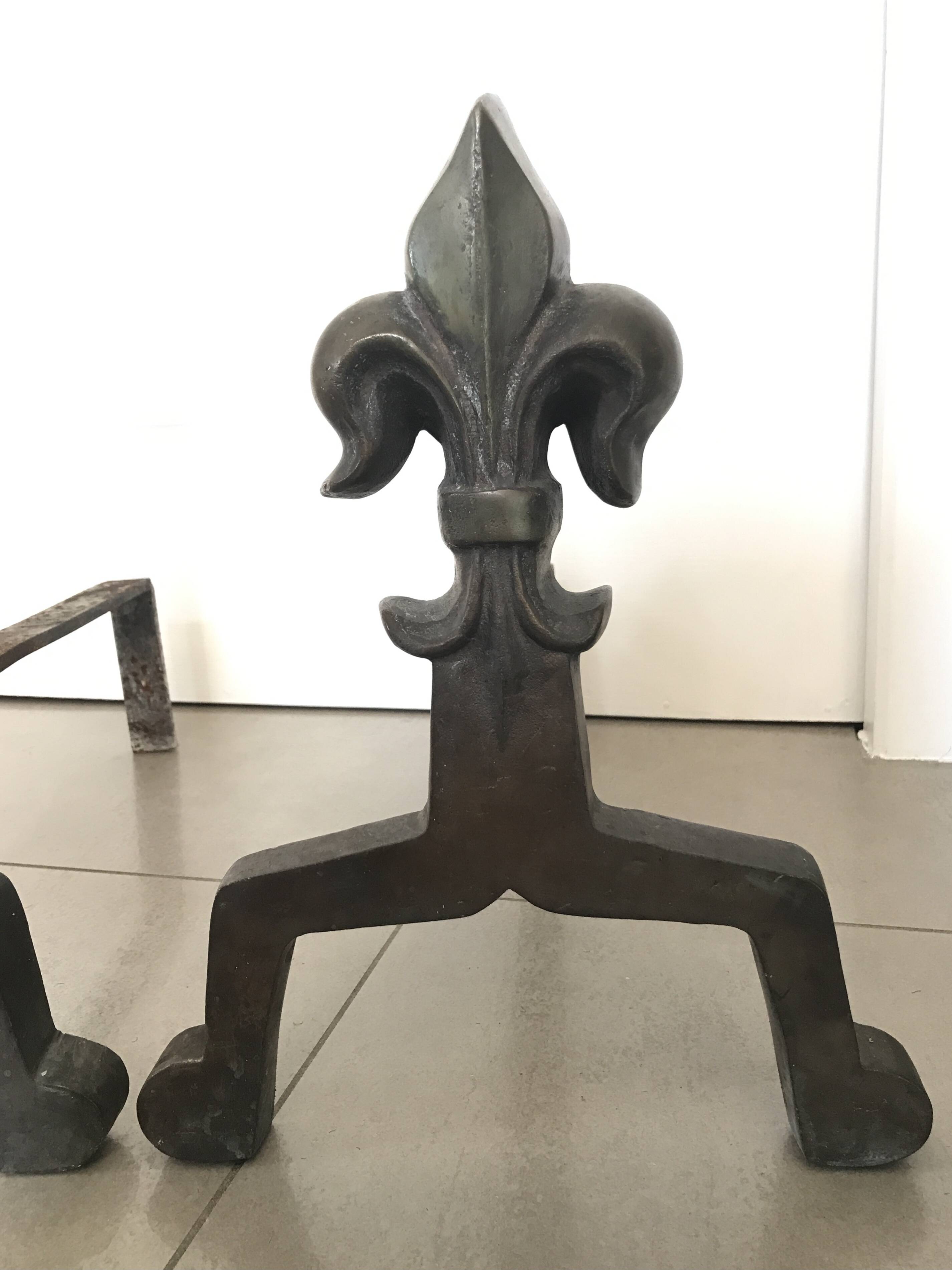 Pair of bronze fireplace firedogs with fleur-de-lys decor, art deco