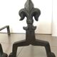 Pair of bronze fireplace firedogs with fleur-de-lys decor, art deco