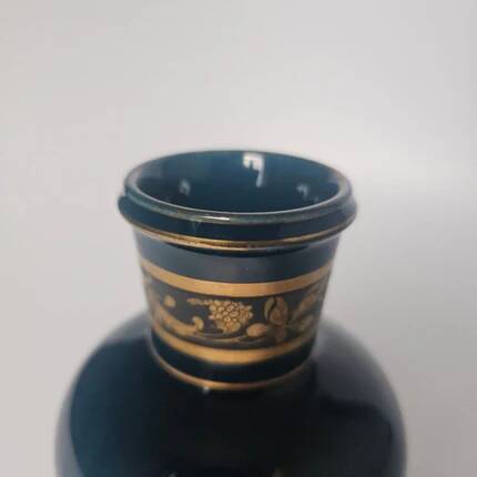 Small turquoise blue and gold porcelain vase with elegant floral patterns.