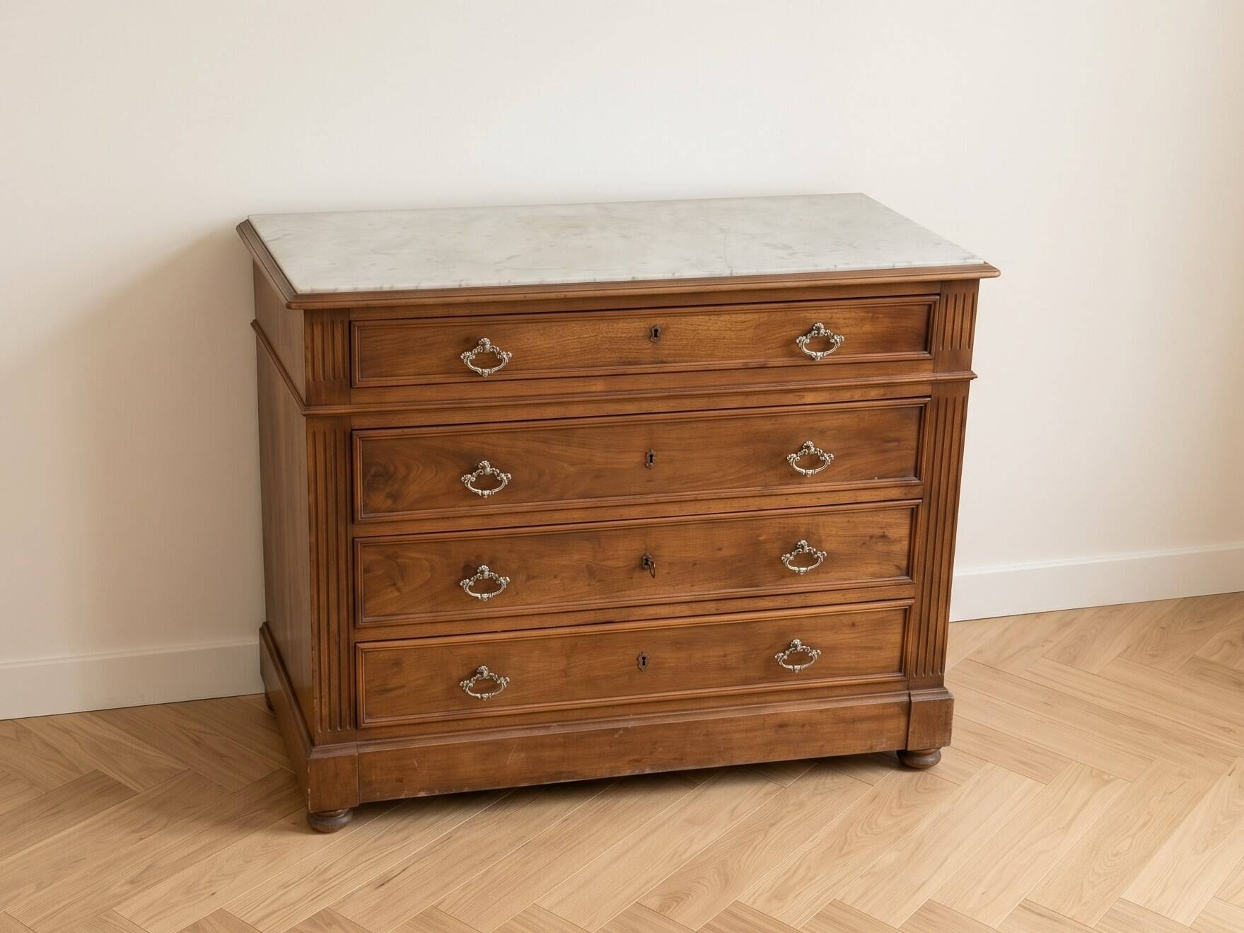 Antique wooden chest of drawers with a marble top.