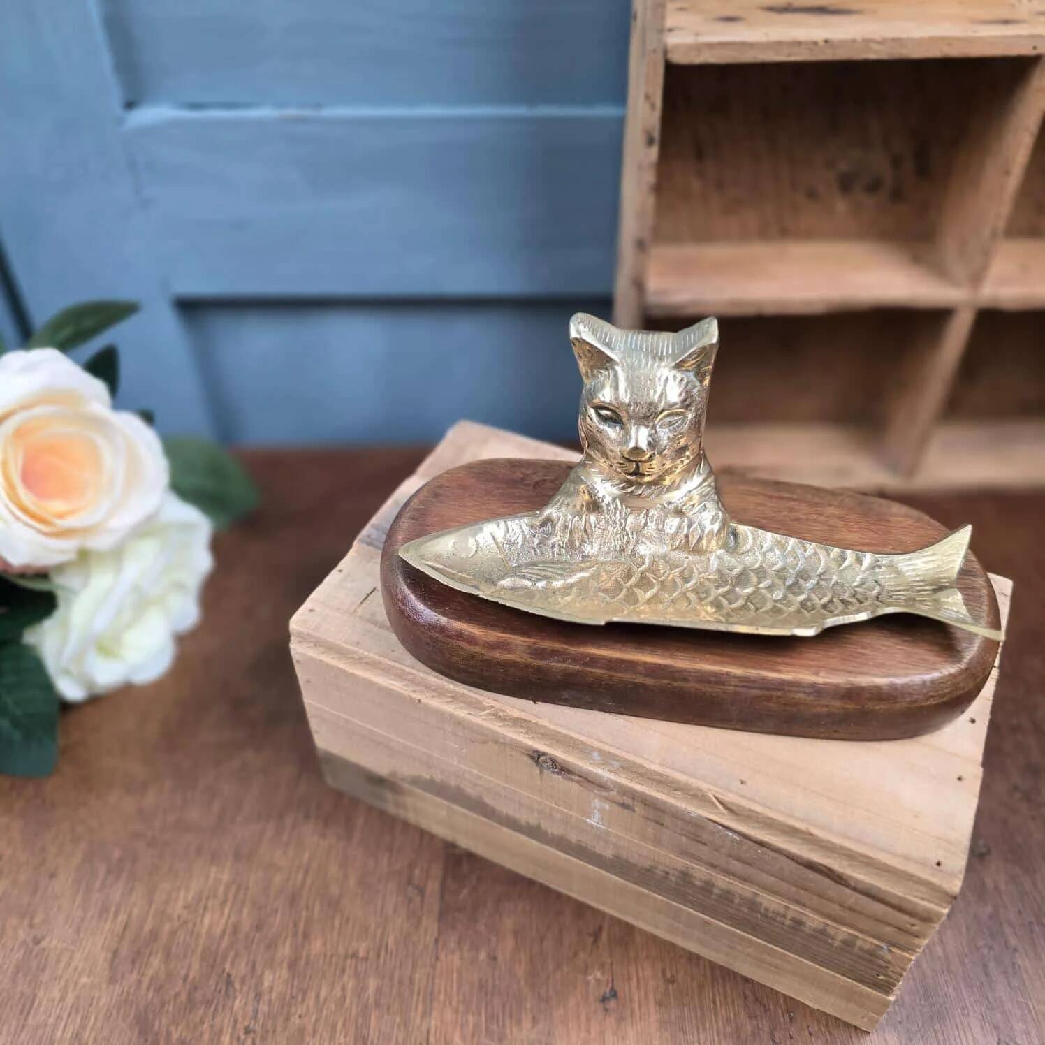 Vintage cat fish catchall in brass on a solid wood base.