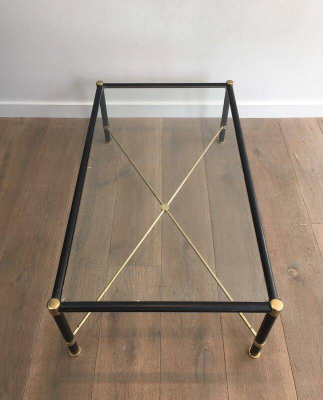 Brass coffee table upholstered in black leather. In the style of Jacques Adnet.