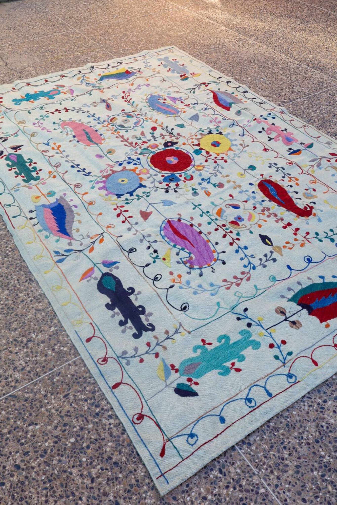White suzani kilim rug with hand embroidered multi-colored patterns