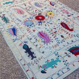 White suzani kilim rug with hand embroidered multi-colored patterns