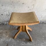 Vintage natural wood stool with light yellow faux leather seat and crossed splayed base
