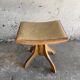 Vintage natural wood stool with light yellow faux leather seat and crossed splayed base
