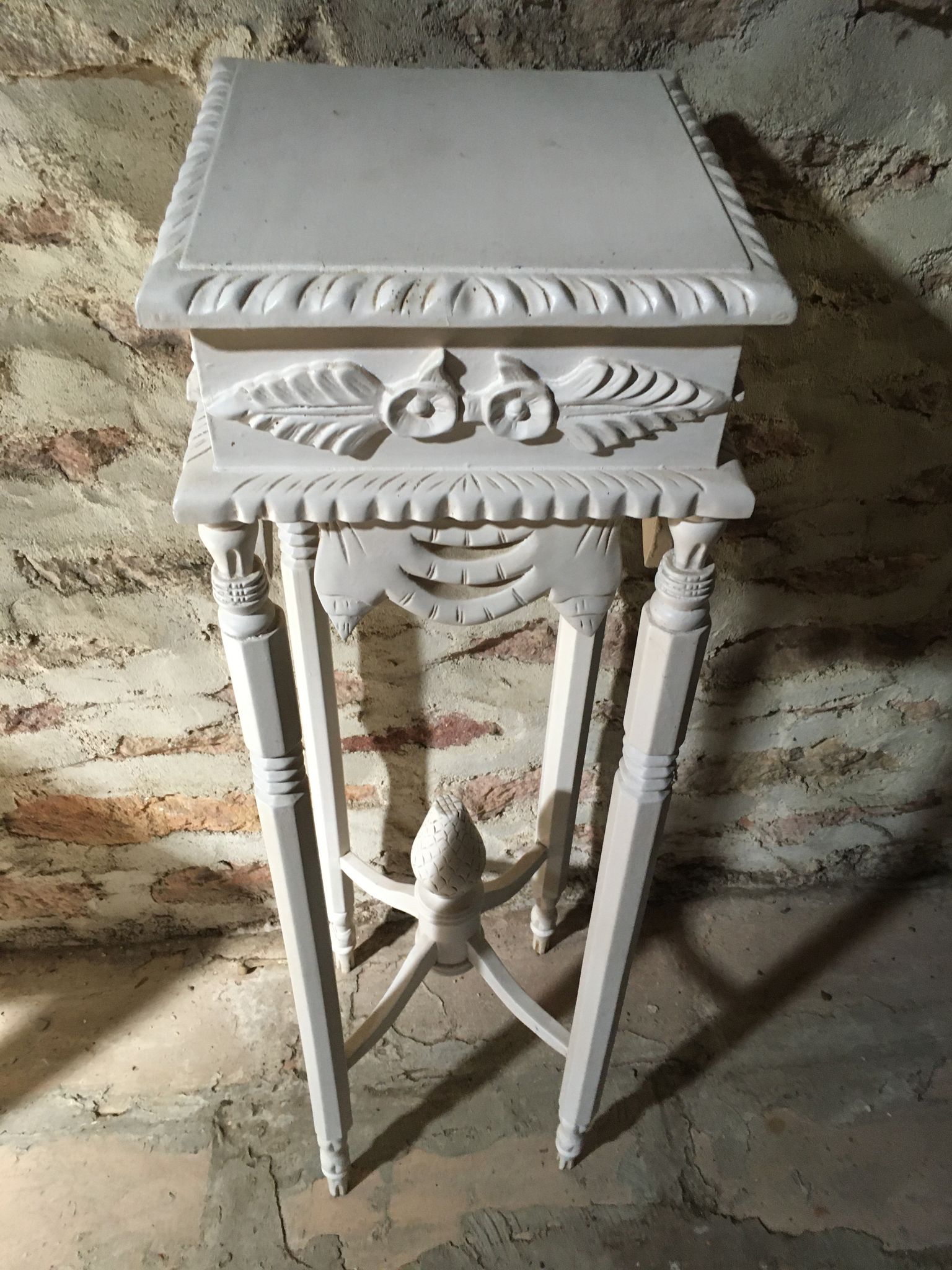 Carved wooden stool with a white patina.
