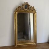 Late 19th century gilded mirror with decorated pediment. 125x70.