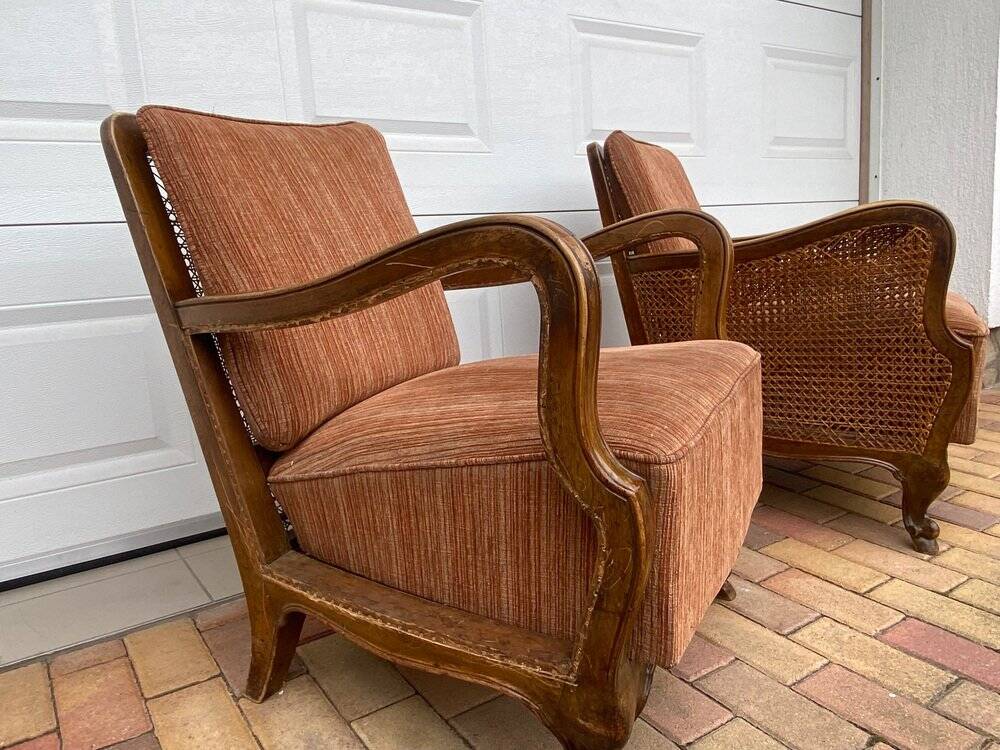 Pair of 1920s brown armchairs in carved wood and fabric, with caning detail.