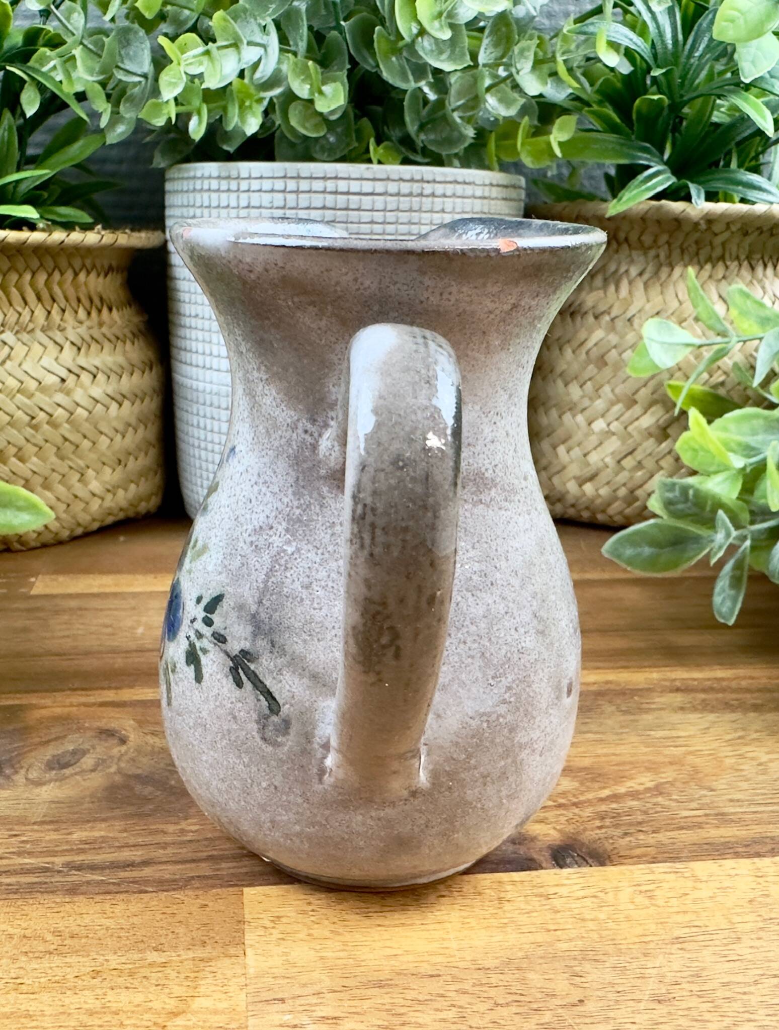 Vintage grey ceramic pitcher with hand-painted blue flower decoration.