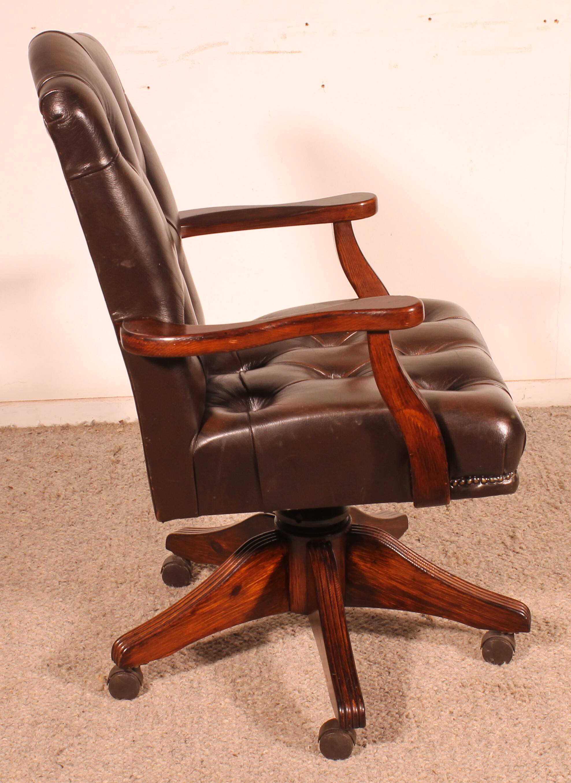 Office chair known as a director's chair in wood and tufted leather.