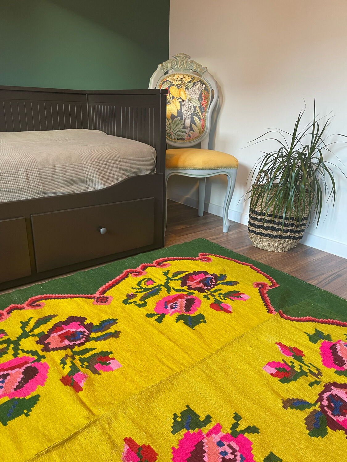 Vintage wool rug with pink flowers on green and yellow background made by hand in Transylvania