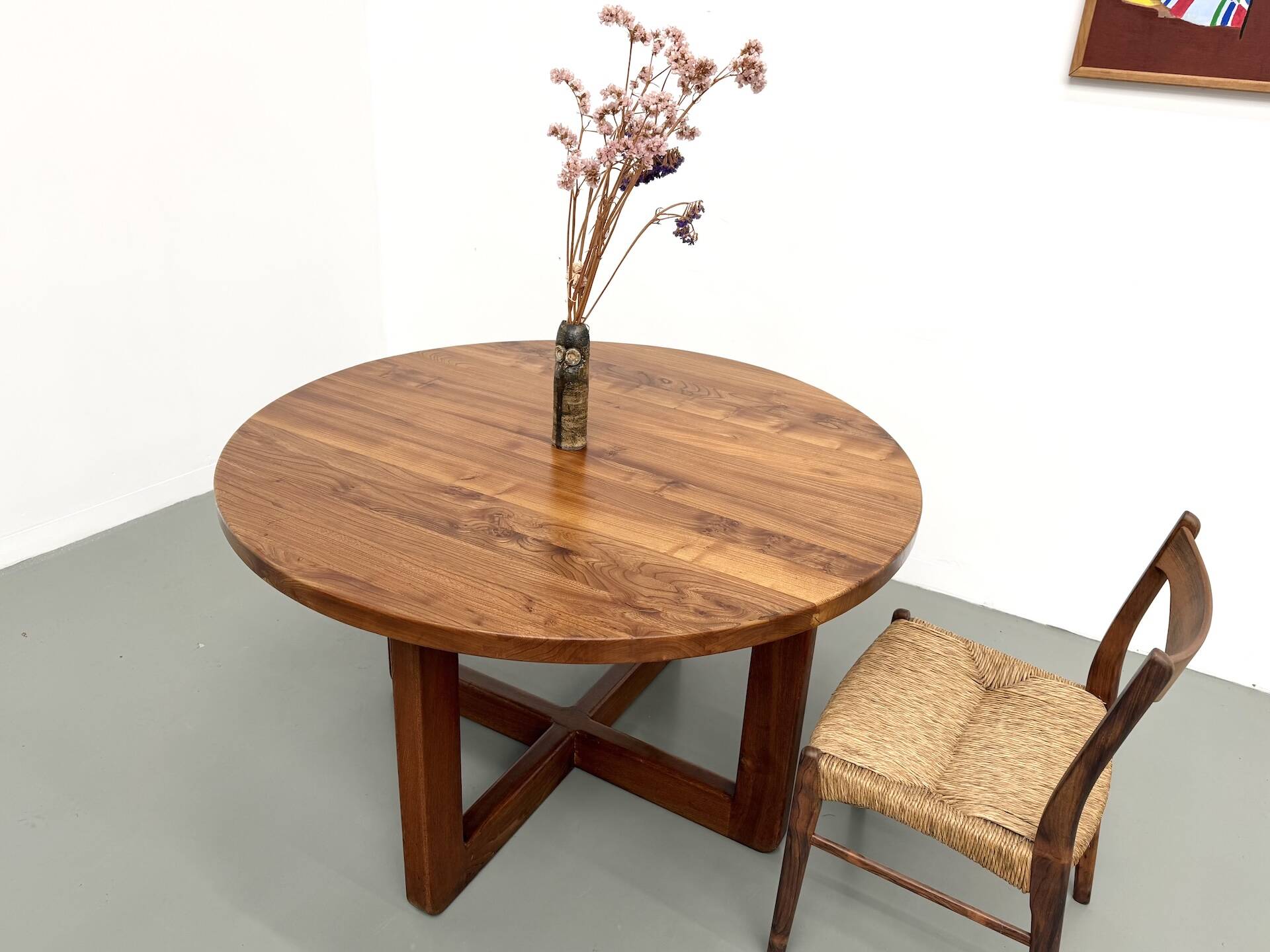 Modernist round table in solid elm, crossed legs.