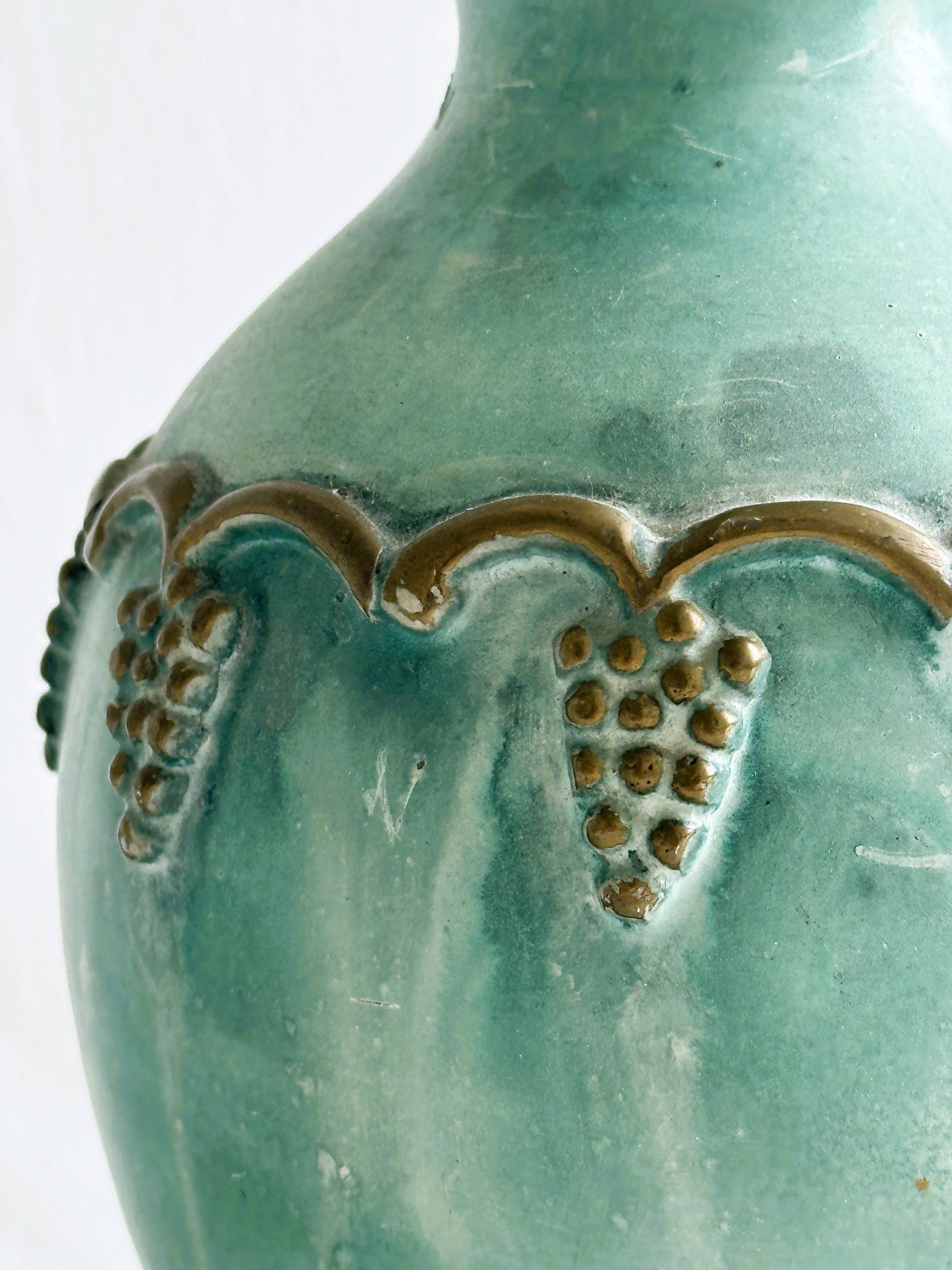 Brass vase decorated with bunches of grapes.