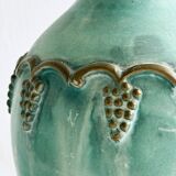 Brass vase decorated with bunches of grapes.
