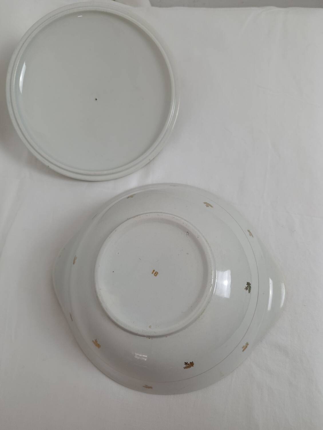 White earthenware soup tureen with a golden pattern.