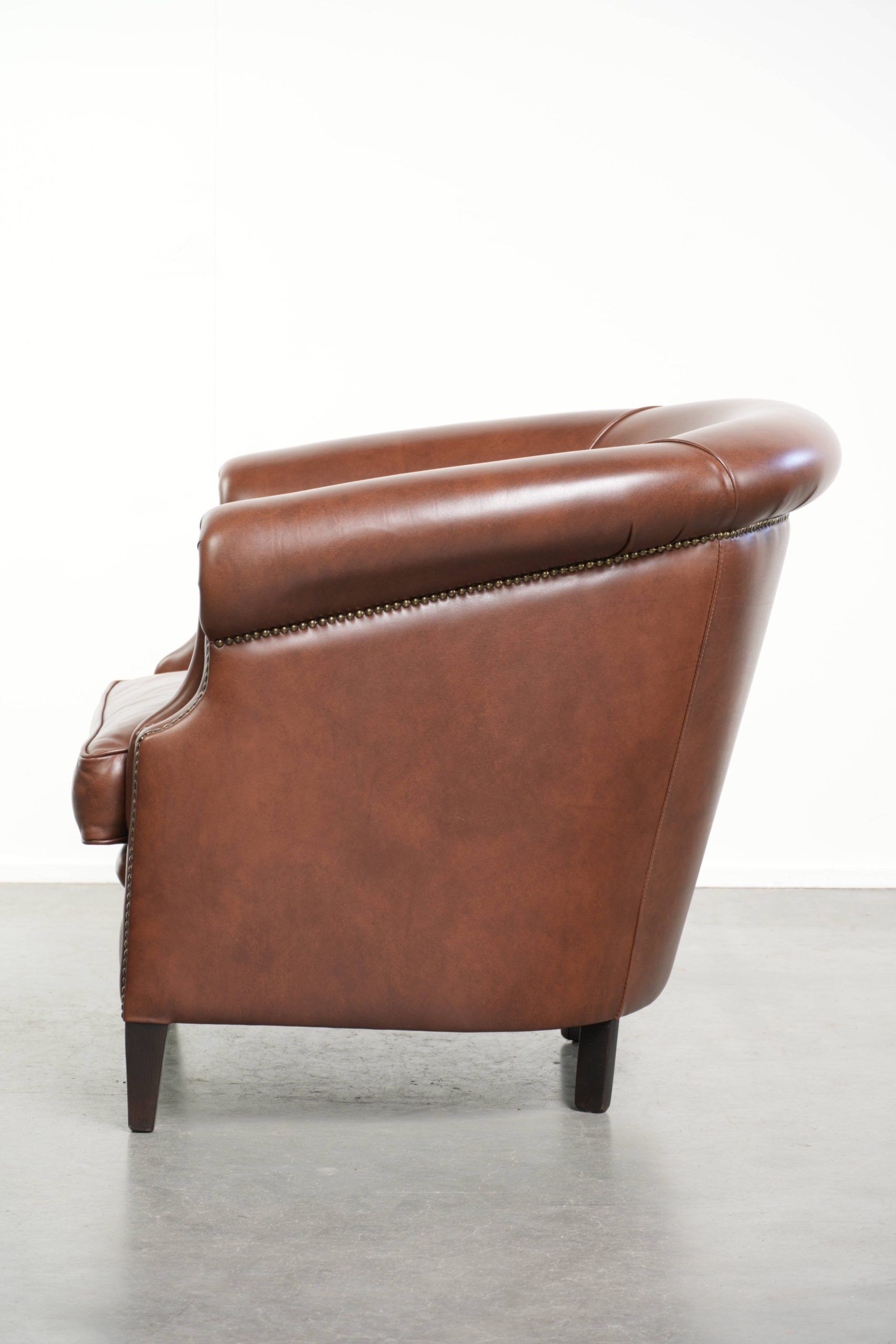 Comfortable cognac-coloured cow leather club armchair in English style