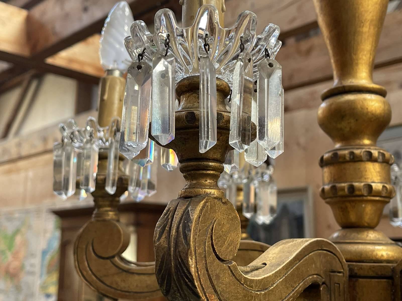 Golden wooden chandelier with crystal pendants from the 19th century.
