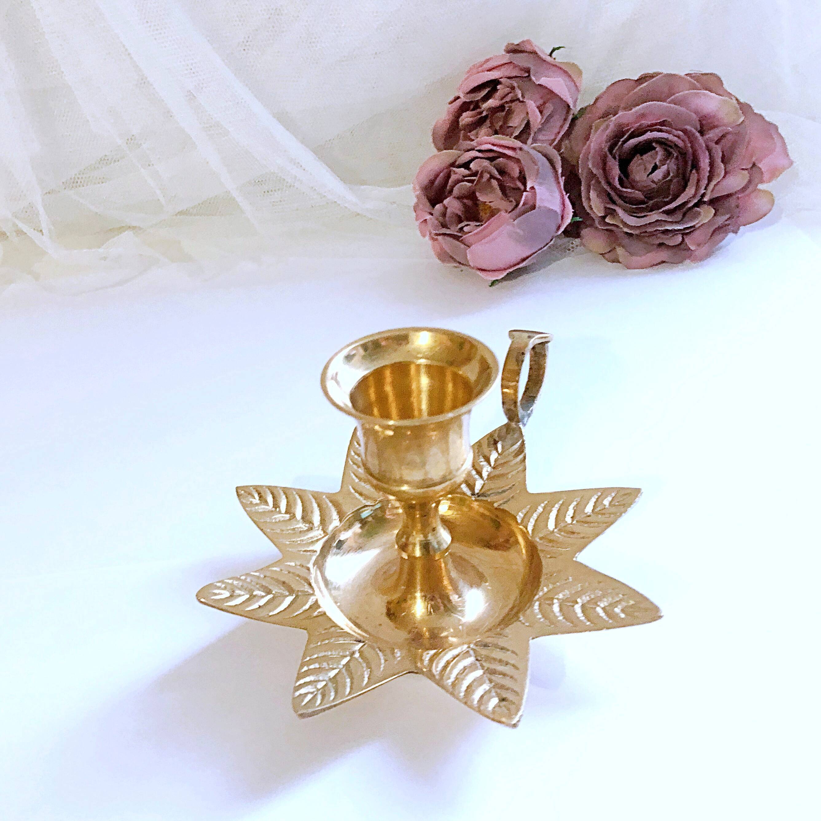 Golden brass hand candle holder decorated with leaves