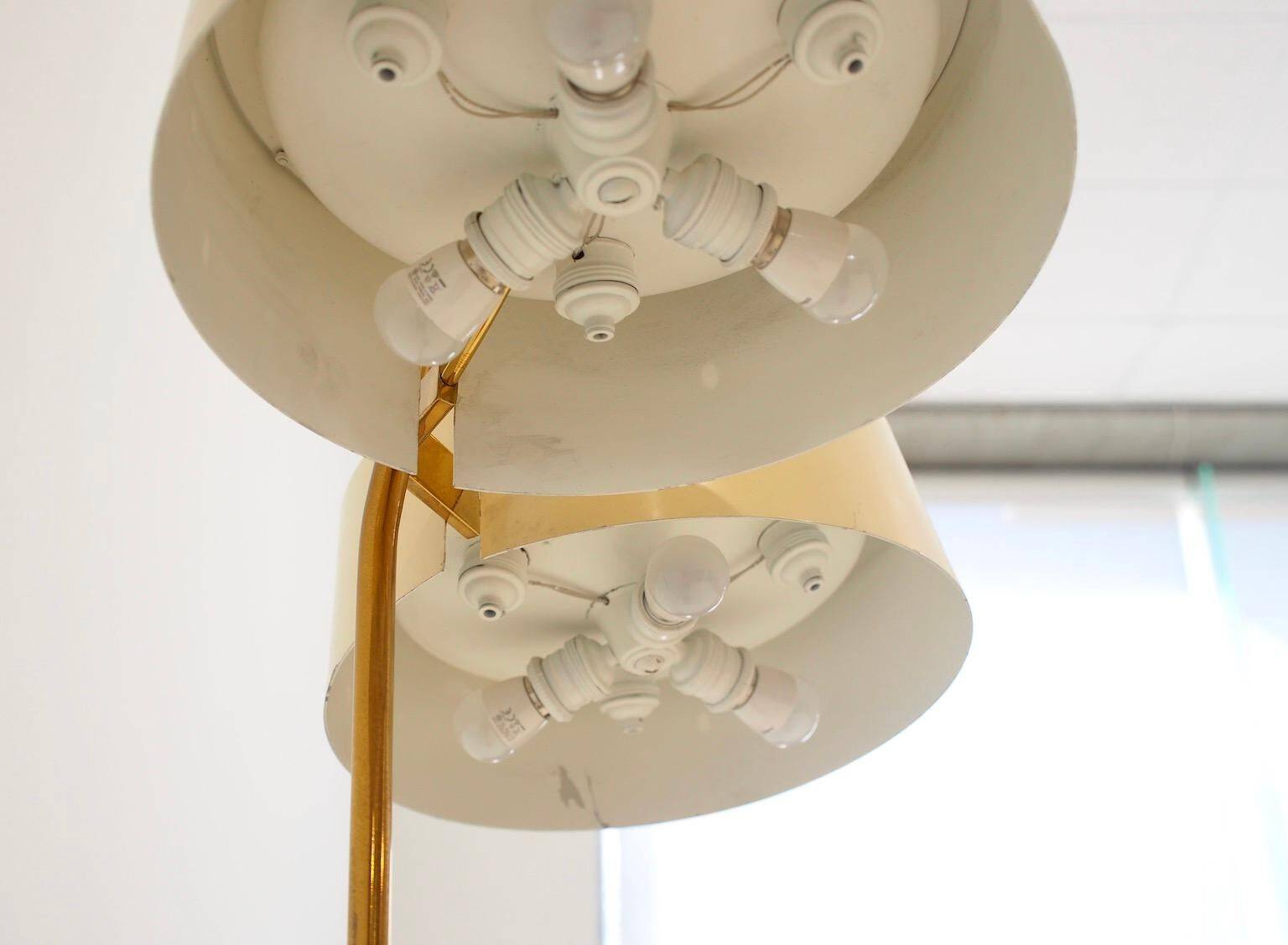 Brass and lacquered metal floor lamp with a wooden magazine shelf.