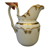 Milk jug or antique pitcher in white and gold porcelain.