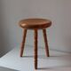 Vintage en bois tourné tabouret du milieu du siècle avec un siège épais.