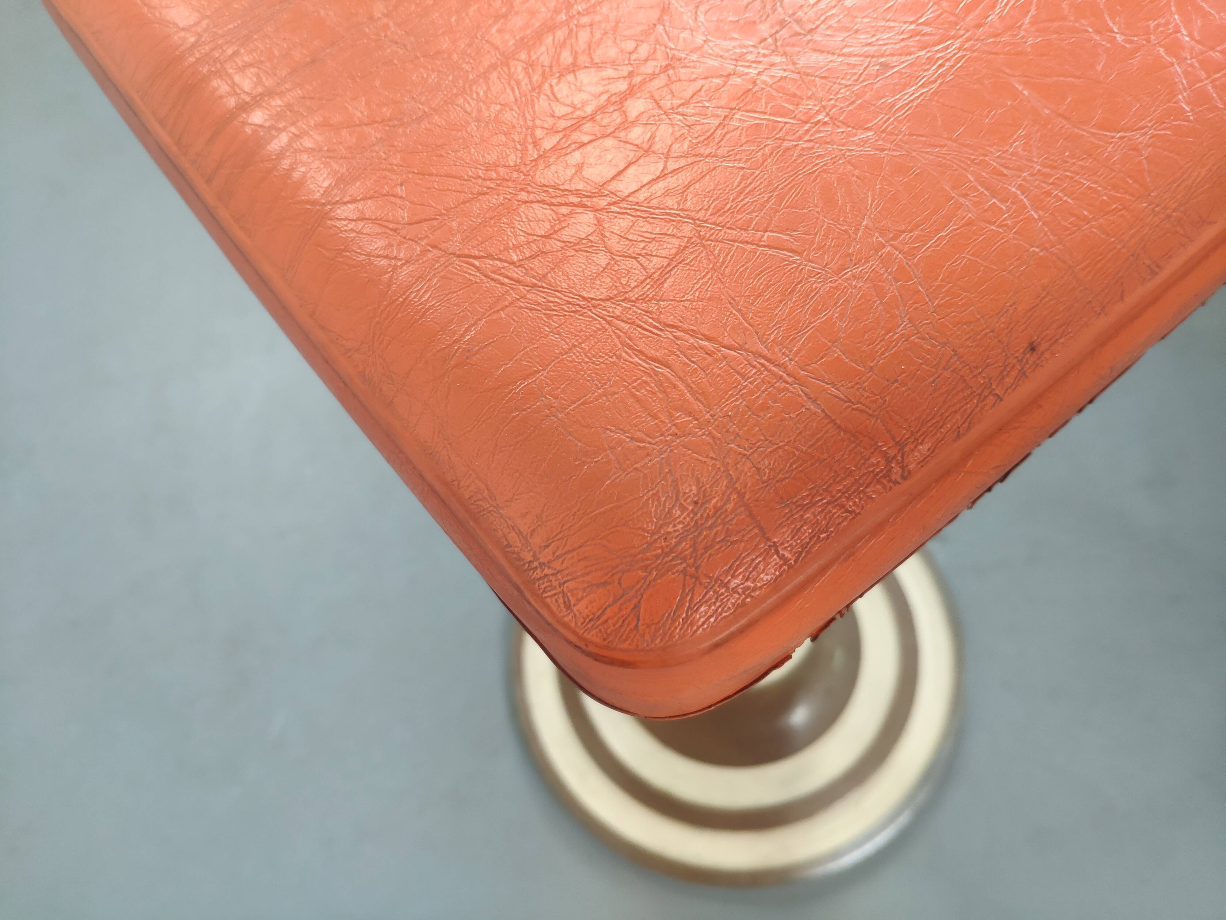 Old swivel orange sitting dentist stool