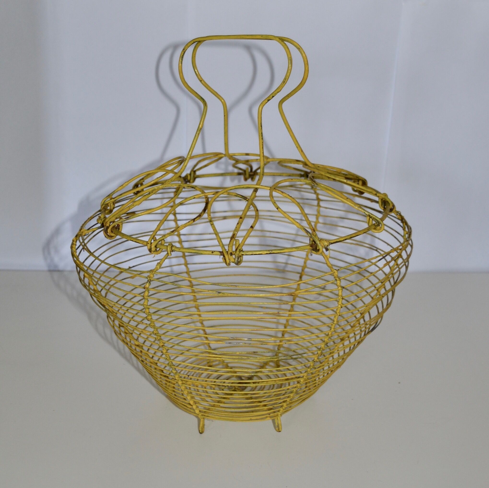 Old egg basket in yellow metal wire