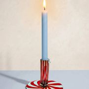 Murano glass candlestick with swirling red and blue ribbons.